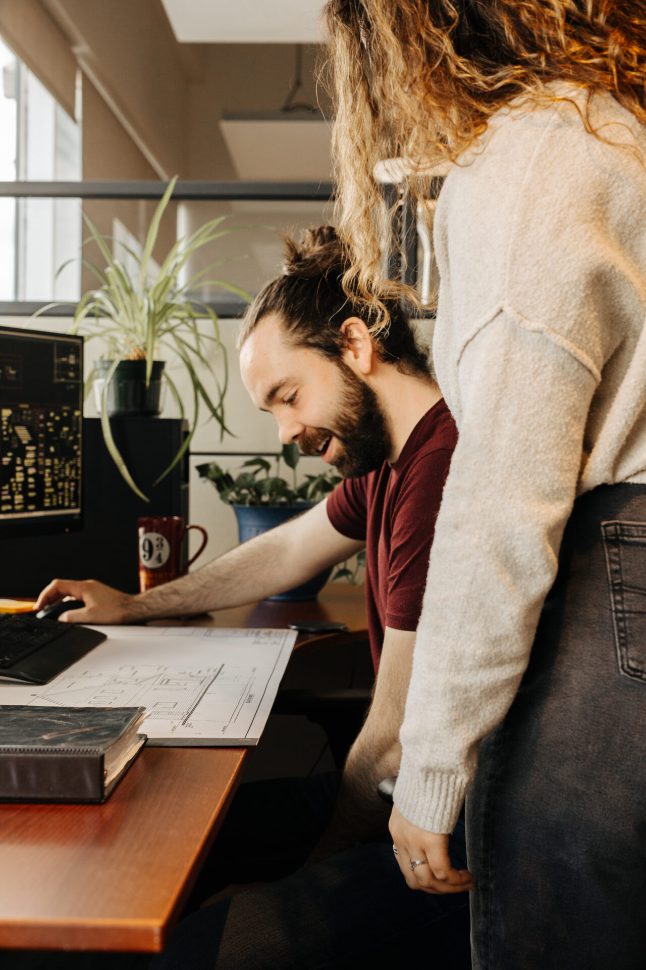 Deux technologues en architecture de Dessins Drummond travaillent sur un plan de maison sur mesure dans un bureau moderne