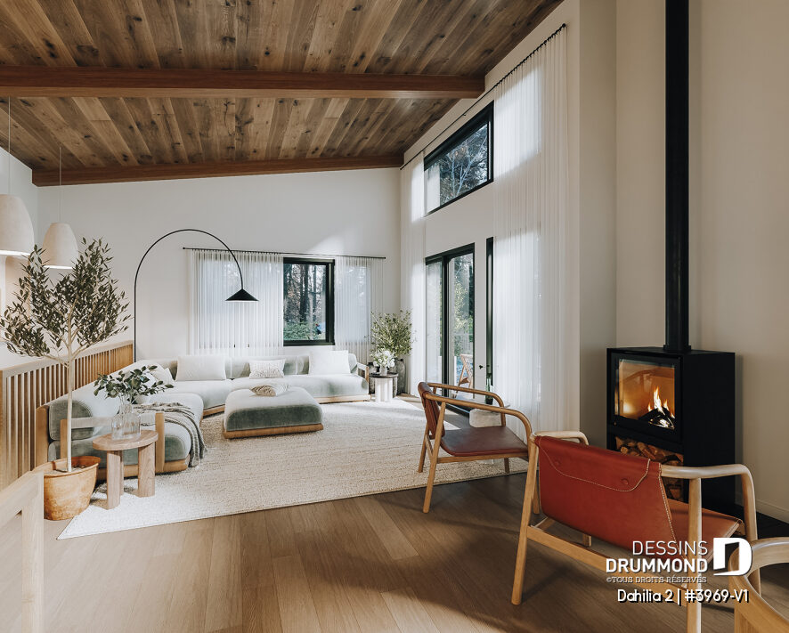 Salon lumineux d'un plan de chalet avec rez-de-jardin Dahilia 2, avec plafond cathédrale, grandes fenêtres et foyer STÛV.
